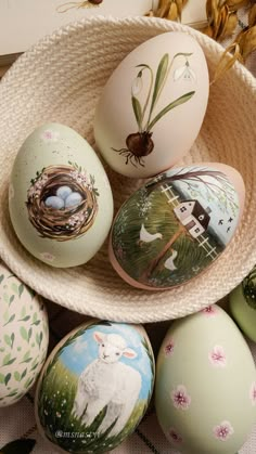 several painted eggs in a bowl on a table