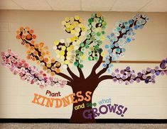 a bulletin board with buttons on it and a tree made out of the words plant kindness and see what grows