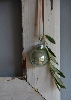 an ornament hanging from the side of a wall next to a green plant