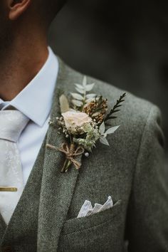 Groom wears rustic pastel rose buttonhole tied with brown string Boho Grooms Boutonniere, Men Buttonhole Wedding, Wedding Button Holes Rustic, Men’s Wedding Flower, Men’s Buttonholes, Champagne Wedding Dress With Groom, Enchanted Forest Wedding Groom Attire, Groom Buttoniere Wedding, European Groom Suit