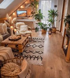 a living room filled with lots of furniture and plants on top of wooden flooring