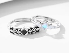 two rings that are sitting on top of each other with an opal stone in the middle