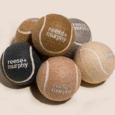 six tennis balls with words written on them in different colors and sizes, all stacked together