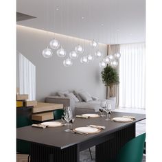 a dining room table is set with place settings for six people and the lights are hanging from the ceiling