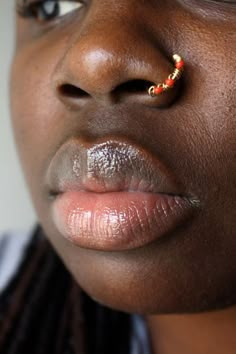 a close up of a person with a nose ring on their left side of the face