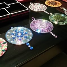 there are many different colored plates on the table with beadwork and beads around them