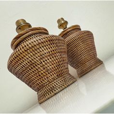 two brown wicker vases sitting on top of a white counter