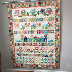 an owl themed quilt hanging on the wall