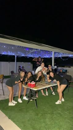 a group of people posing for a photo in front of a table with drinks on it