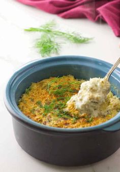 a blue bowl filled with food on top of a table