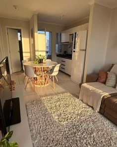 a living room filled with furniture and a dining table next to a kitchen counter top