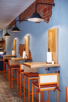 a row of chairs sitting next to each other in front of a wall mounted mirror