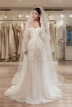 a woman standing in front of a wedding dress