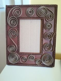 a brown frame with swirls on it sitting on top of a table