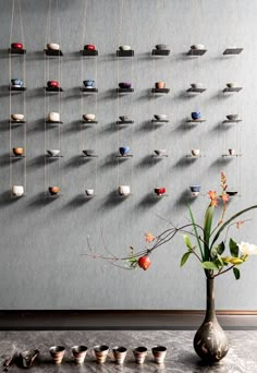 a vase filled with flowers sitting next to a wall covered in magnets and pins