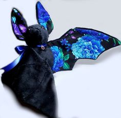 a bat stuffed animal with blue flowers on it