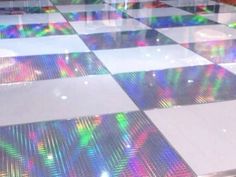 a checkered floor with colorful lights on it in a room that looks like something out of space