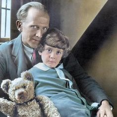 an older man sitting next to a young boy with a teddy bear in his lap