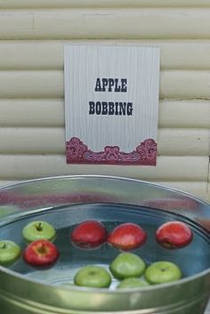 an apple cobbling machine with apples in it and a sign on the wall behind it