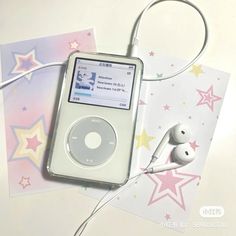 an ipod and earphones on top of some cards