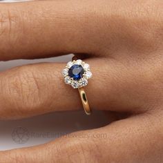 a woman's hand with a blue and white diamond ring