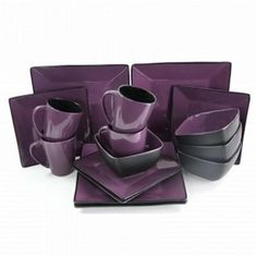 a purple and black dinnerware set on a white background