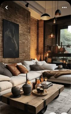 a living room filled with lots of furniture next to a brick wall and flooring