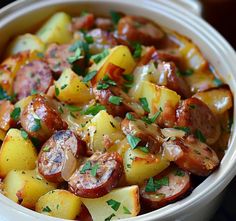 a white bowl filled with potatoes and sausage