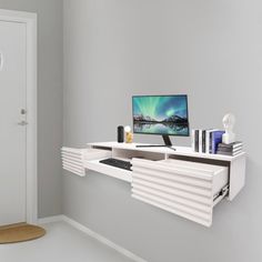 a computer monitor sitting on top of a white shelf