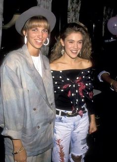 two people standing next to each other wearing hats