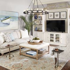 a living room filled with furniture and a large painting on the wall above it's fireplace