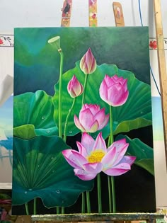 a painting of pink flowers and green leaves on a easel with paintbrushes