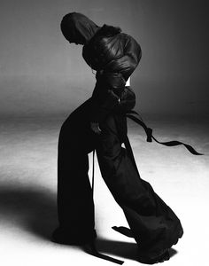 black and white photograph of a woman with her back to the camera, wearing a long dress