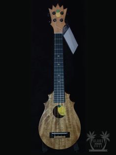 the ukulele is made out of wood and has a crown on it's head