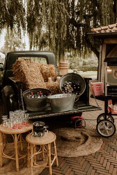 an old pick up truck is loaded with hay and other things to sell on the back