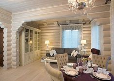 a dining room table set for four in front of a living room with couches and chairs