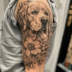 a man's arm with a dog and flowers on it