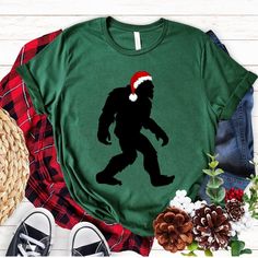 Sasquatch Christmas T-shirt, Bigfoot Santa Hat Shirt, Bigfoot Holiday Tee, Funny Christmas Shirts Our Bella + Canvas style 3001, is a popular unisex style that is eco friendly and known for its durability. This tee is relaxed fit more narrow than a traditional men's cut, but not as fitted as women's tee. Customers should size down for a more fitted look and size up for a looser fit in the adult sizes. *youth sizes are a more standard fit. *See size chart in photos. *Rolled up Sleeves are for style purposes. T-SHIRT MATERIALS Solid colors: 100% airlume combed and ring-spun cotton Heather colors: 52% airlume combed and ring-spun cotton, 48% polyester Athletic Heather: 90% airlume combed and ring-spun cotton, 10% polyester Care instructions: Turn shirt inside out Machine wash in cold water Dr Sasquatch Christmas, Unique Tshirt Designs, Tshirt Design Diy, Sasquatch Shirt, Rolled Up Sleeves, Unique T Shirt Design, Santa Shirt, Nfl Shirts, Santa Shirts