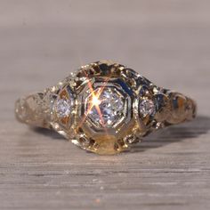 an antique diamond ring sitting on top of a wooden table