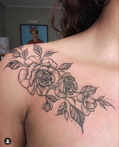 a woman's shoulder with flowers and leaves tattoo on her left side breast area