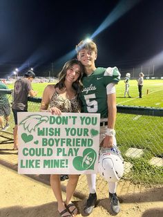 two people standing next to each other holding a sign that says don't you wish your boyfriend could play like mine