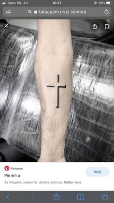 a man's arm with a cross tattoo on the left side of his forearm