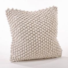 a knitted pillow sitting on top of a white table