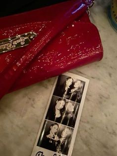 a red purse sitting on top of a counter next to an advertise sticker