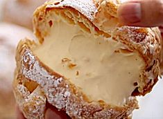 a person holding a piece of bread with cream cheese on it's crusts