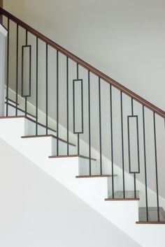 a white stair case with metal handrails and glass balconies