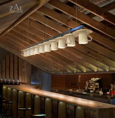 a bar with several lights hanging from the ceiling and stools in front of it