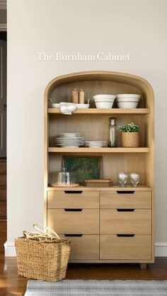 an open bookcase with bowls and plates on it in front of a white wall