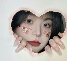 a woman's face is seen through a hole in the wall with stickers on it