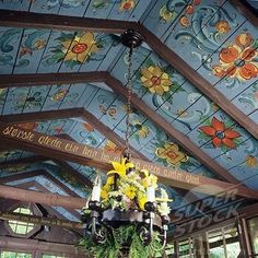 a chandelier hanging from the ceiling in a room with painted walls and ceilings